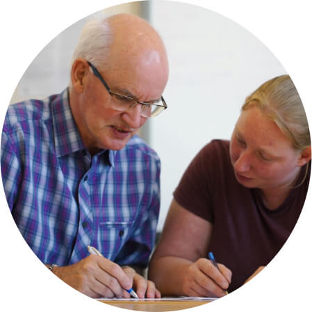 >Two people helping each other with writing